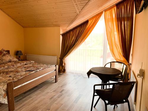 een slaapkamer met een bed en 2 stoelen en een raam bij Апартаменти "Золота Баня" in Skhidnitsa