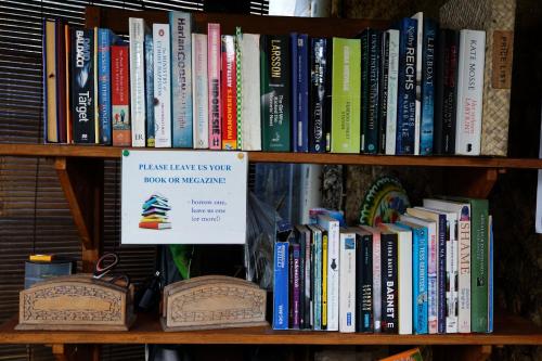 a book shelf filled with lots of books at Louto Dmell Villa & Guesthouse in Sanur