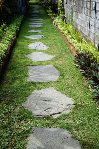 a path with stepping stones in the grass at Louto Dmell Villa & Guesthouse in Sanur