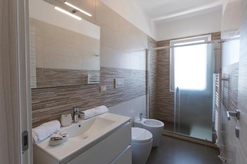 a white bathroom with a sink and a toilet at Spuma di mare in Gallipoli