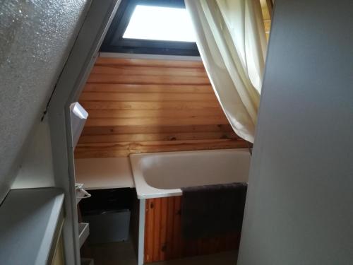 a small bathroom with a tub and a window at Chalet 2 chambres in Les Angles