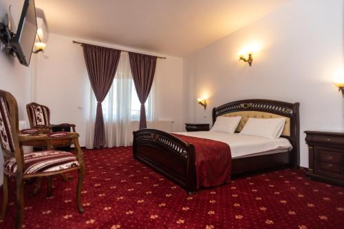 een slaapkamer met een bed, een bureau en een stoel bij Tango margo in Iaşi