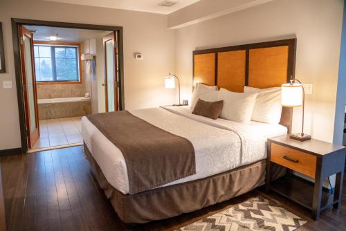a hotel room with a large bed and a bathroom at Pocaterra Inn & Waterslide in Canmore