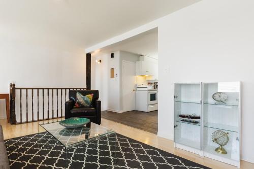 a living room with a couch and a glass table at Espace William by Hébergements DCL in Quebec City