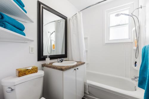 e bagno con servizi igienici bianchi, lavandino e vasca. di Espace William by Hébergements DCL a Québec