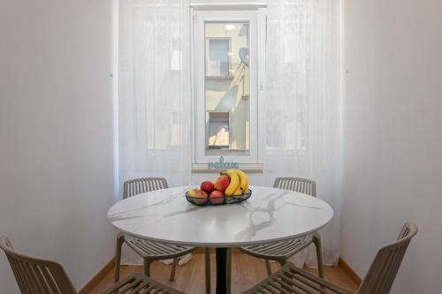 a bowl of fruit on a white table in a room at La Preziosa Rooms in Pula