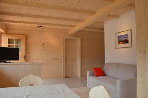 a living room with a couch and a tv at Zyprianhof in Nova Levante