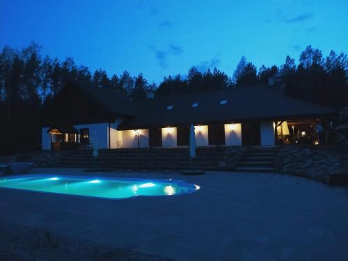 a house with a swimming pool at night at Majątek Morgi in Suchowola