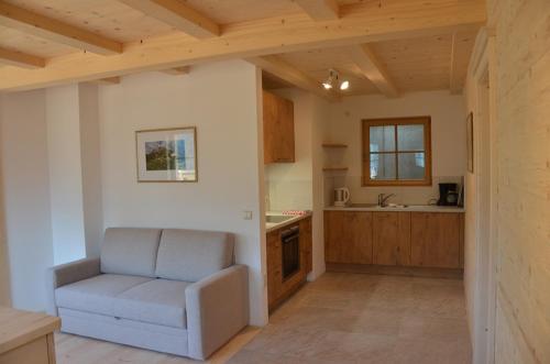 a living room with a chair and a kitchen at Zyprianhof in Nova Levante