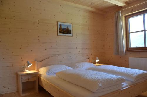 a bedroom with a bed in a wooden wall at Zyprianhof in Nova Levante