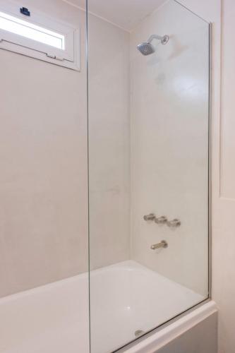 a shower with a glass door and a sink at Soho Point Central in Buenos Aires