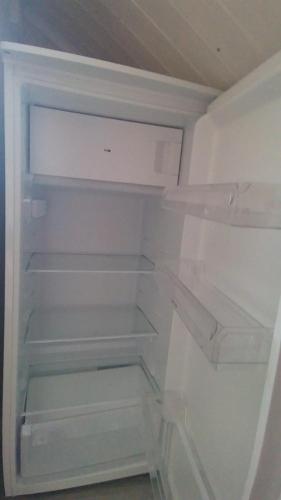 an empty refrigerator with its door open in a room at Blue House II at the end of the World in Mehamn
