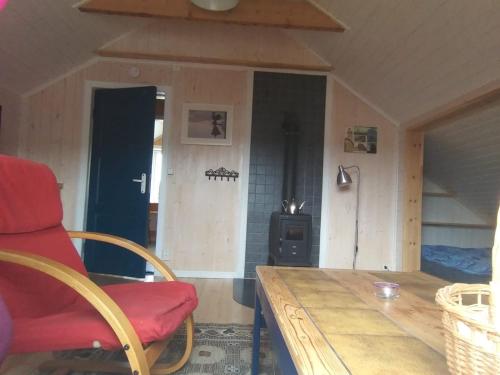 a room with a wooden table and a red chair at The Blue House at The End Of The World II in Mehamn