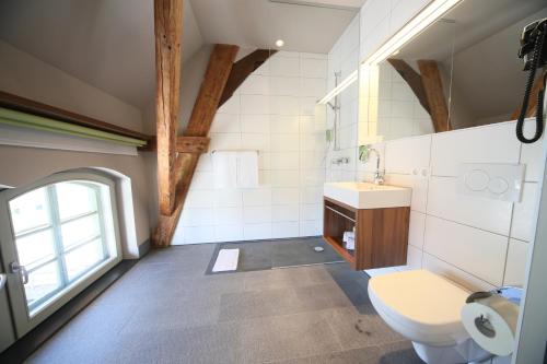 La salle de bains est pourvue de toilettes, d'un lavabo et d'une fenêtre. dans l'établissement Hotel Kunstmühle, à Mindelheim