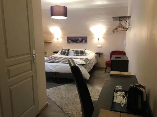 a hotel room with a bed and a table and chairs at Auberge de la Paix in Briançon