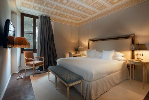 a bedroom with a large white bed and a chair at Il Salviatino Firenze in Florence