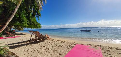 a sandy beach with a boat in the water at Hotel ECOLODGE LE RAVORAHA in Sainte Marie