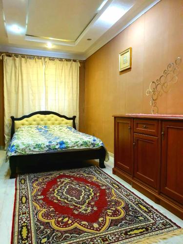 a bedroom with a bed and a rug on the floor at Apartment Ushakova 16 in Dnipro