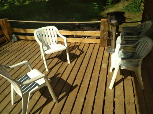 two chairs and a table on a deck at Chalet - Au retour vers Soi in Les Nobertins