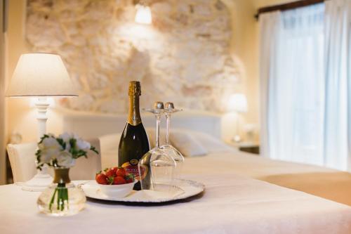 a table with a bottle of wine and a bowl of fruit at Rooms Villa Duketis in Rovinj