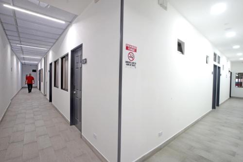 a hallway of a building with a person walking down it at Hotel San José in San José
