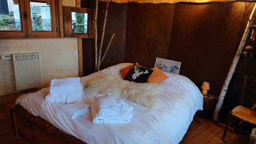 a bed with a teddy bear laying on it at Les Cabanes Du Saleve in Collonges-sous-Salève