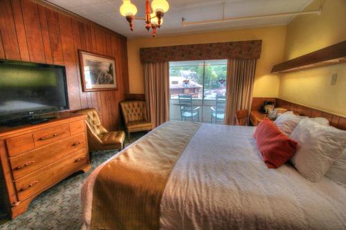 a bedroom with a large bed and a flat screen tv at Gatlinburg Inn in Gatlinburg