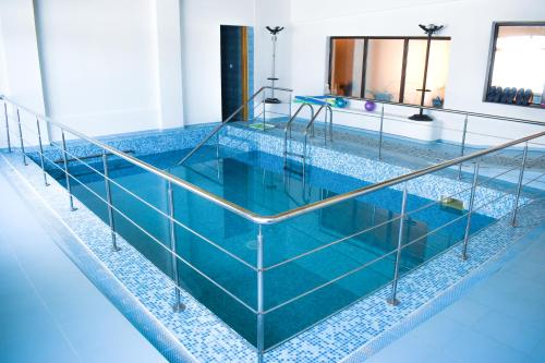 a swimming pool with blue water and metal railing at Complex Fortuna in Eforie Sud