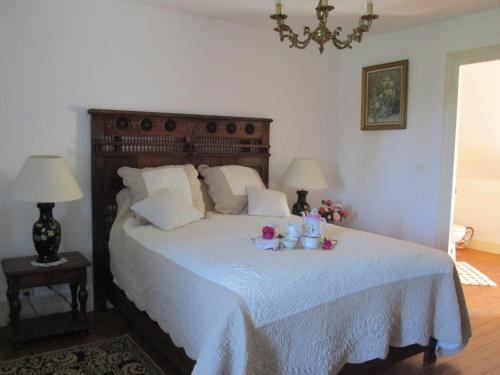 - une chambre avec un grand lit fleuri dans l'établissement Le domaine de Beaufai, à Beaufai