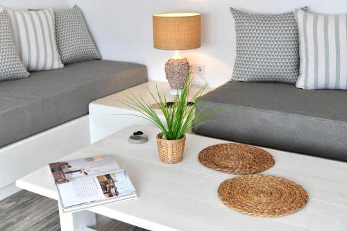a living room with a white coffee table with a couch at Ammos Luxury Rooms & Home in Naousa