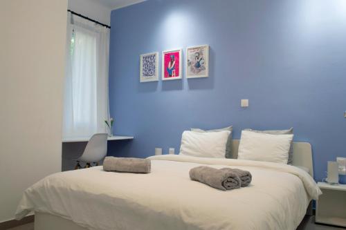 niebieska sypialnia z dużym łóżkiem z ręcznikami w obiekcie KYMA Apartments - Athens Acropolis 5 w Atenach