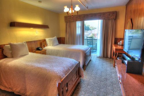 a hotel room with two beds and a television at Gatlinburg Inn in Gatlinburg
