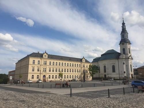 a large building with a clock tower in front of it at Penzion Sklář in Nový Bor