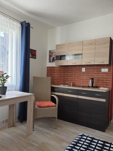 a kitchen with a sink and a table with a chair at Penzion Sklář in Nový Bor