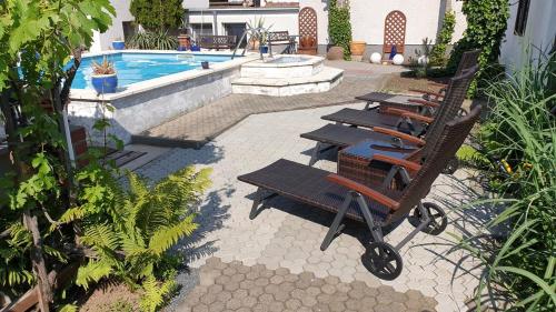 a row of lounge chairs next to a swimming pool at Pension Münch "Am Anger" in Neuseußlitz