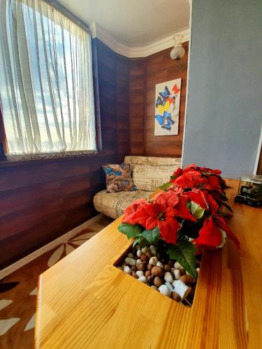 a living room with a table with red flowers on it at Dnipro evening, view # Вечірній Дніпро у центрі, фантастичний вид in Dnipro