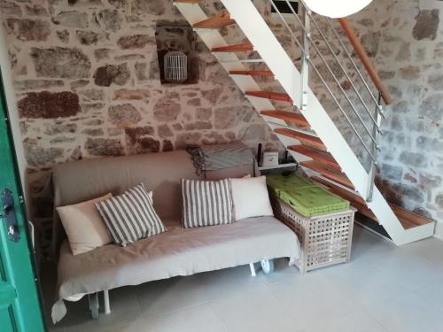 a couch in a room with a brick wall at Krka Waterfalls Stonehouse Roko in Lozovac