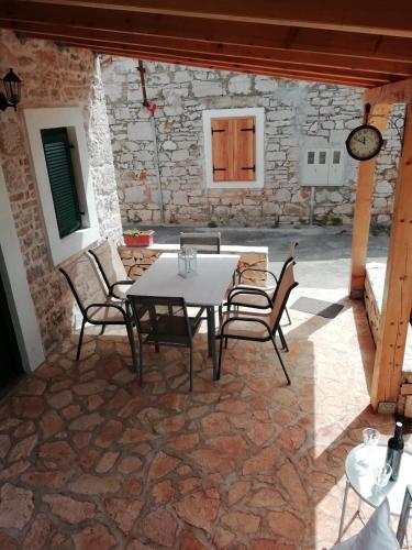 a patio with a white table and chairs at Krka Waterfalls Stonehouse Roko in Lozovac