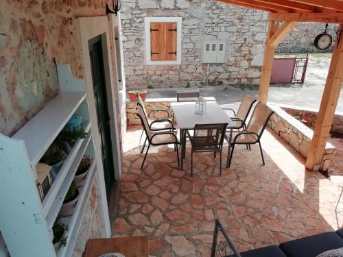 a patio with a table and chairs in a building at Krka Waterfalls Stonehouse Roko in Lozovac