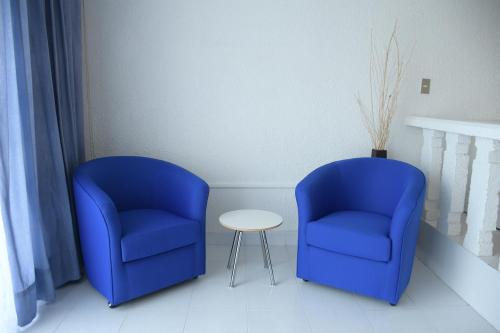two blue chairs and a table in a room at Villa Bejar Cuernavaca in Cuernavaca