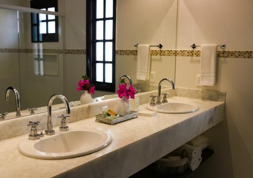 uma casa de banho com 2 lavatórios e um espelho grande em Hotel Capim Limão Itaipava em Itaipava