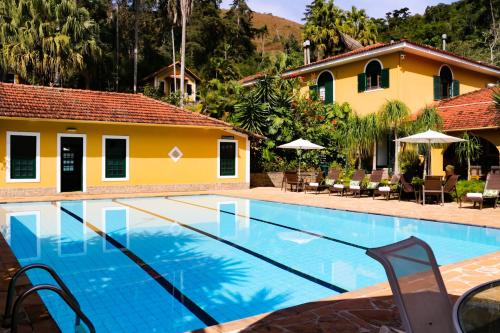 uma piscina em frente a uma casa em Hotel Capim Limão Itaipava em Itaipava