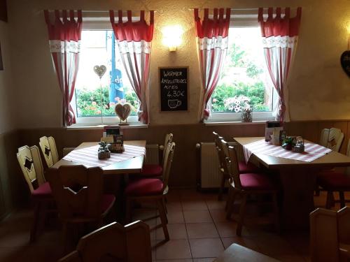 two tables in a restaurant with two windows at Gasthof Lindenkrug in Broderstorf