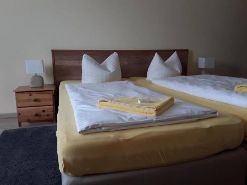 two beds with a book sitting on top of them at Gasthof Lindenkrug in Broderstorf