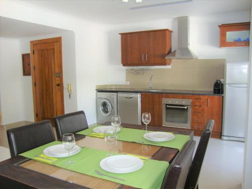 una cocina con una mesa con platos y copas de vino en Belinha Guest House, en Luz