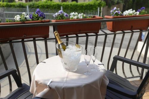 a bottle of champagne sitting on a table with glasses at Hotel da Roberto in Lazise