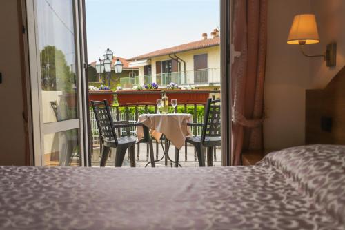 a bedroom with a table and chairs on a balcony at Hotel da Roberto in Lazise