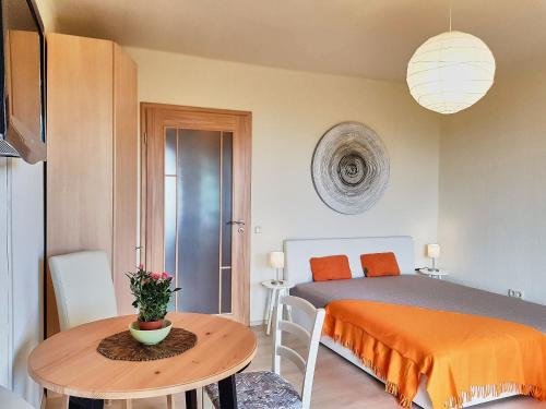 ein Schlafzimmer mit einem Bett und einem kleinen Tisch mit einem sidx sidx in der Unterkunft seeYOU apartment Balatonfüred in Balatonfüred