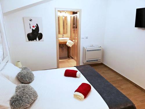 a bedroom with a white bed with red pillows on it at Villa Lucija Cilipi in Čilipi