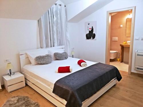 um quarto com uma grande cama branca com almofadas vermelhas em Villa Lucija Cilipi em Cilipi